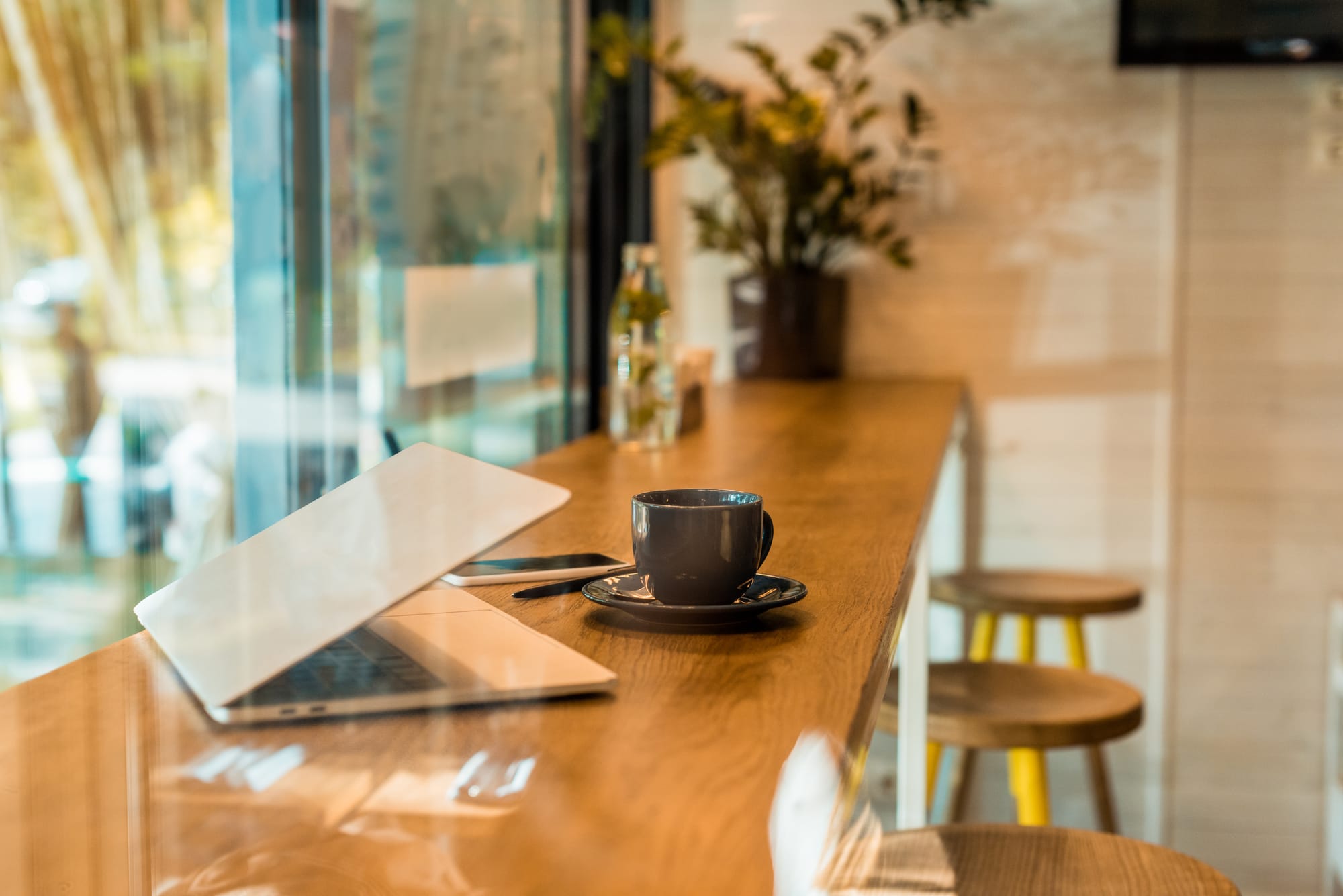 Laptop and coffee sitting on a cafe bar