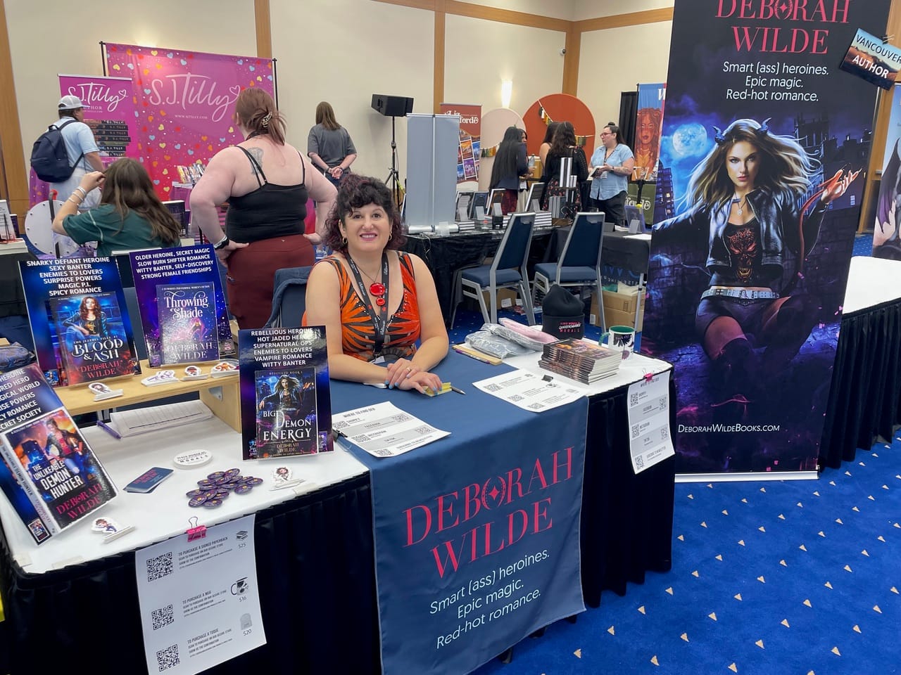 Deborah Wilde smiles from her booth at an author event