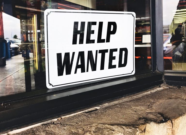 Business needs to hire new employees so they put out a help wanted sign